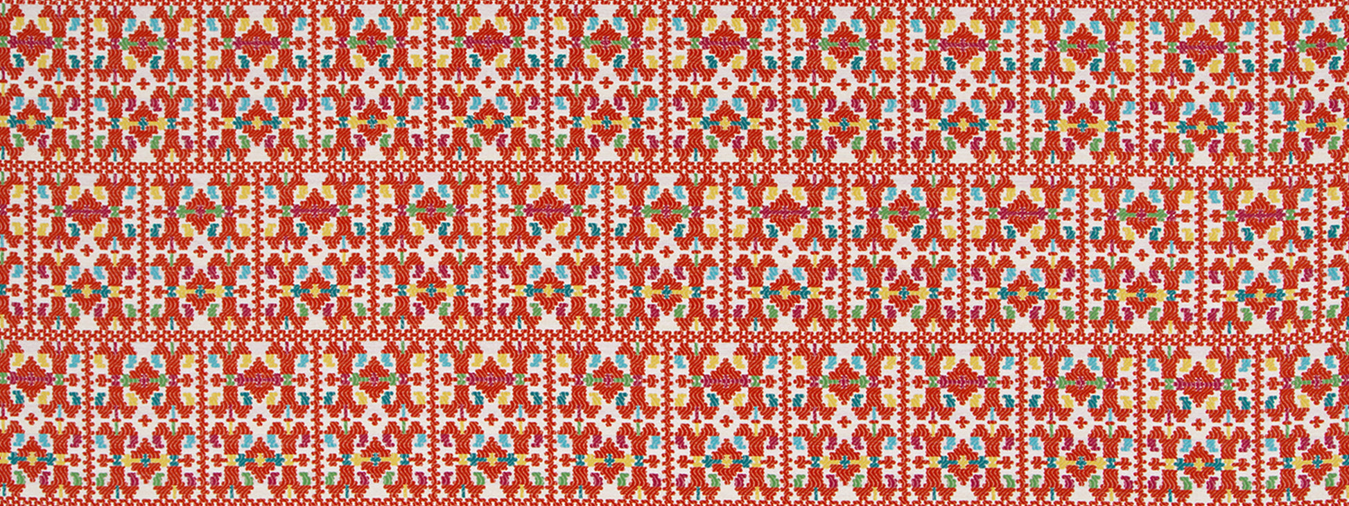 Red upholstery fabric with a repeating papel picado-inspired floral-geometric pattern.