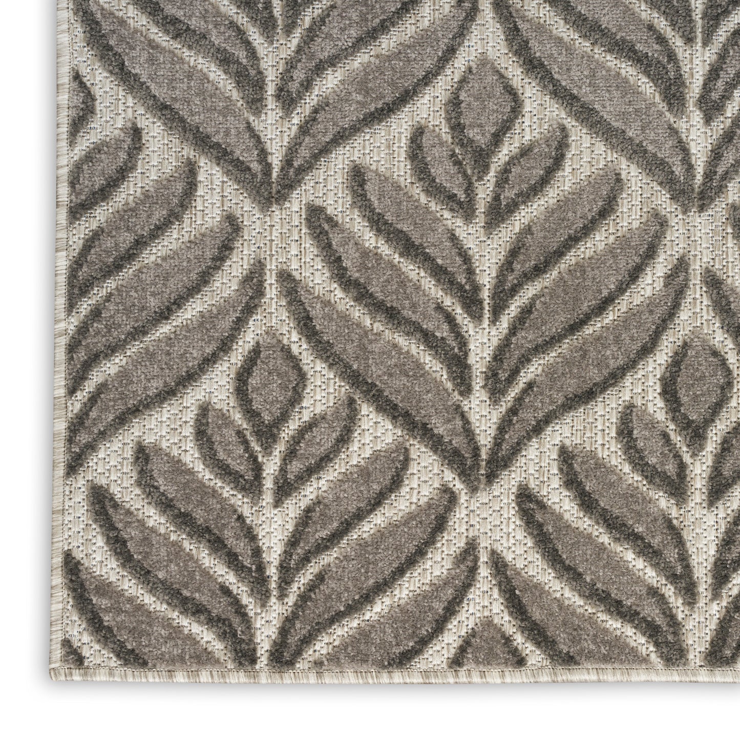 Rectangular beige outdoor runner rug with dark taupe leafy pattern, woven textured surface, bound edge, modern botanical style.