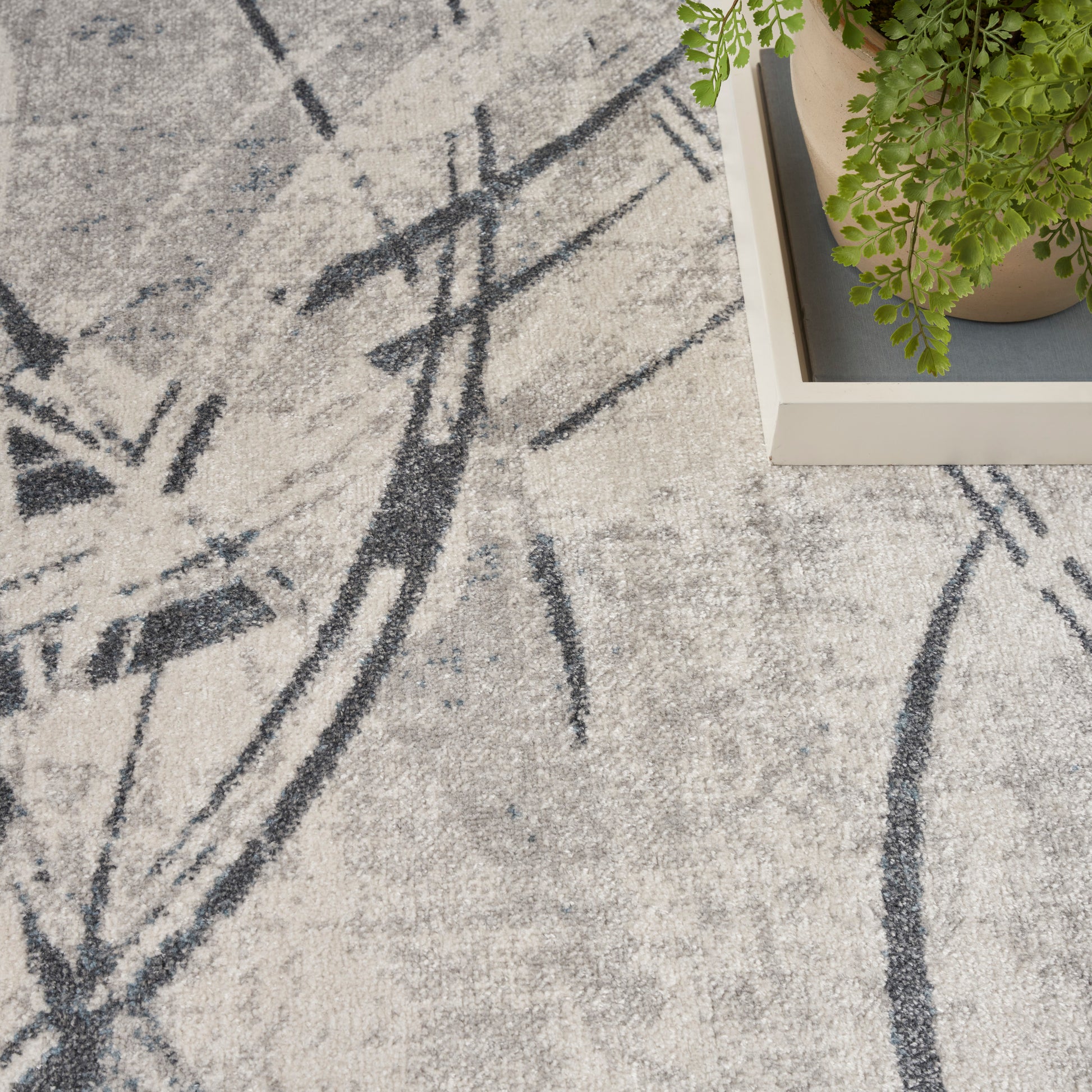 Abstract grey rug with a black linear pattern.