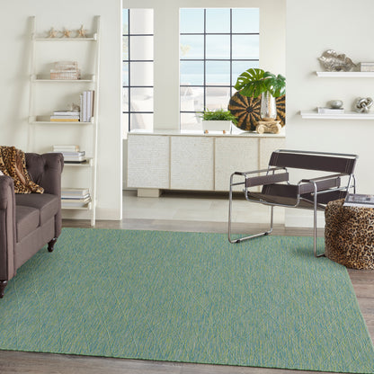 Teal-green textured rug with yellow diagonal lines in a modern living room; black leather-and-chrome lounge chair and leopard-print ottoman.