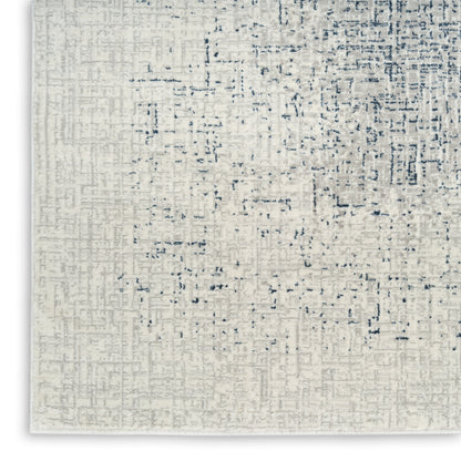 Cream textured area rug with a subtle blue-gray abstract geometric pattern and woven feel.