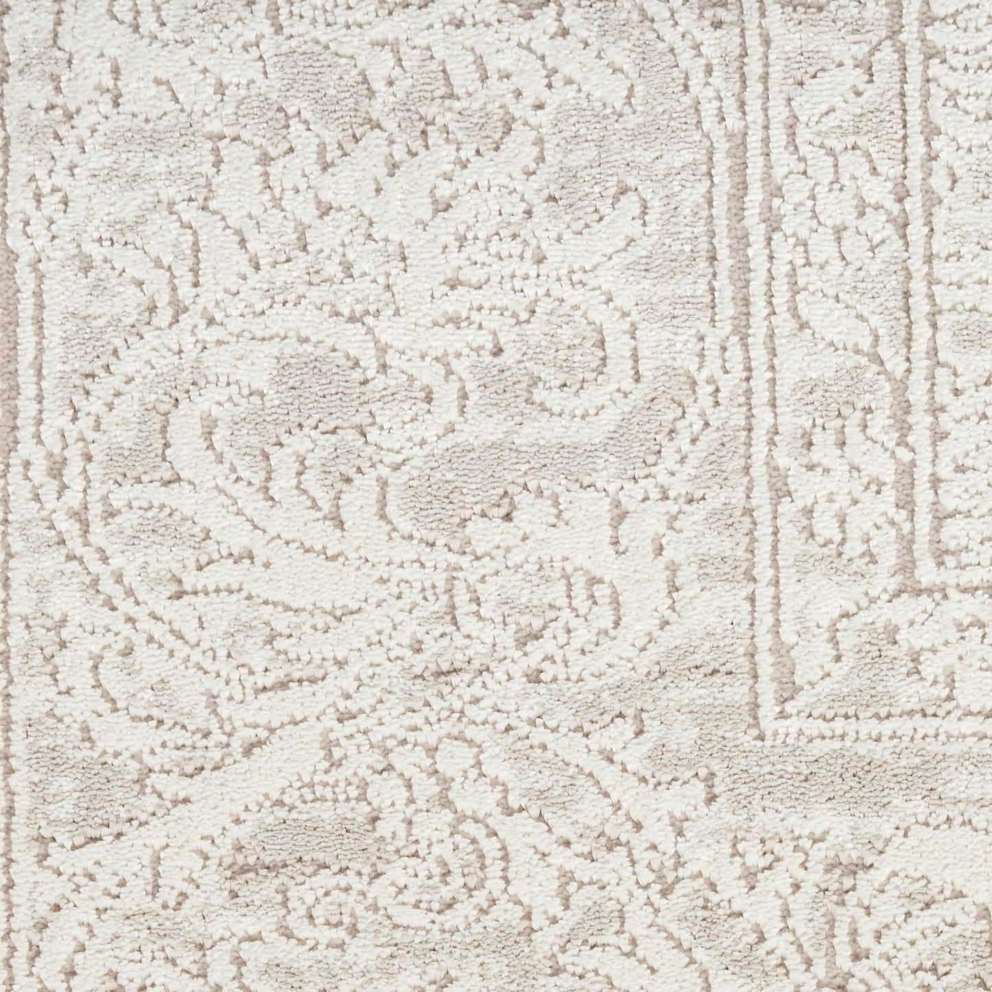 Cream-toned oriental rug with ornate floral scrolls and decorative border; soft woven texture.
