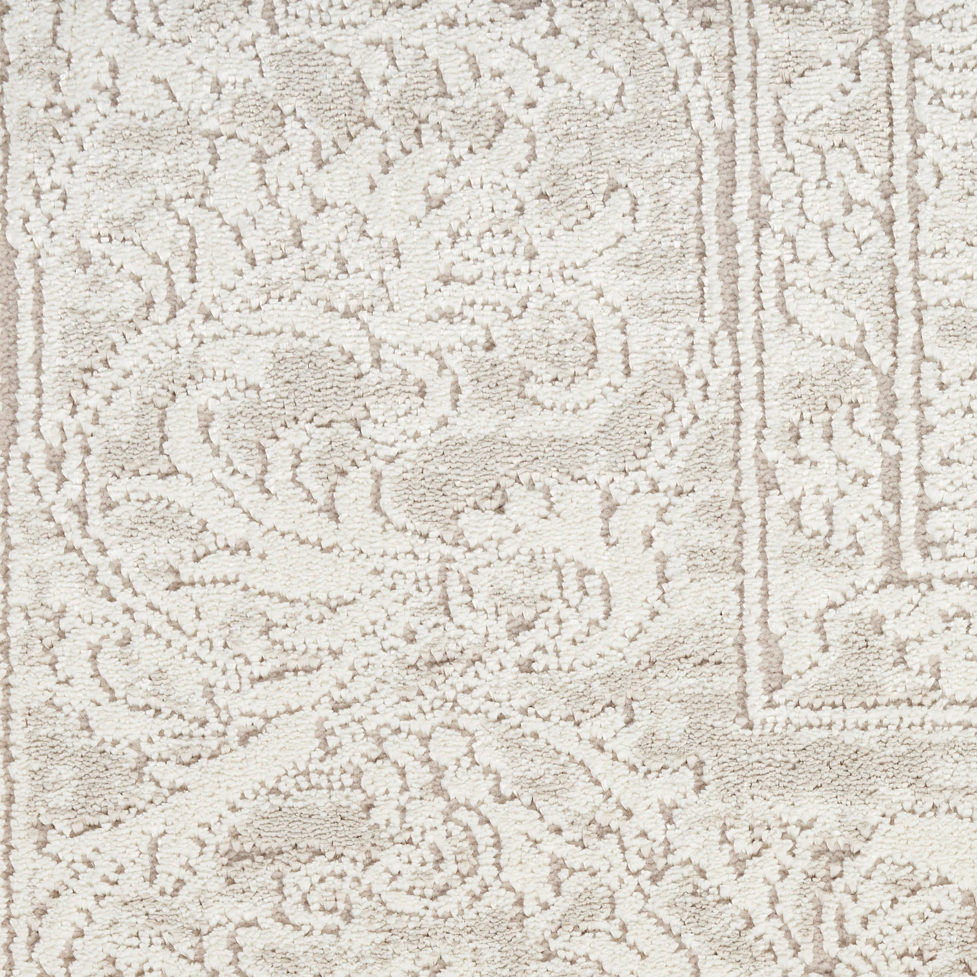 Cream-toned oriental rug with ornate floral scrolls and decorative border; soft woven texture.