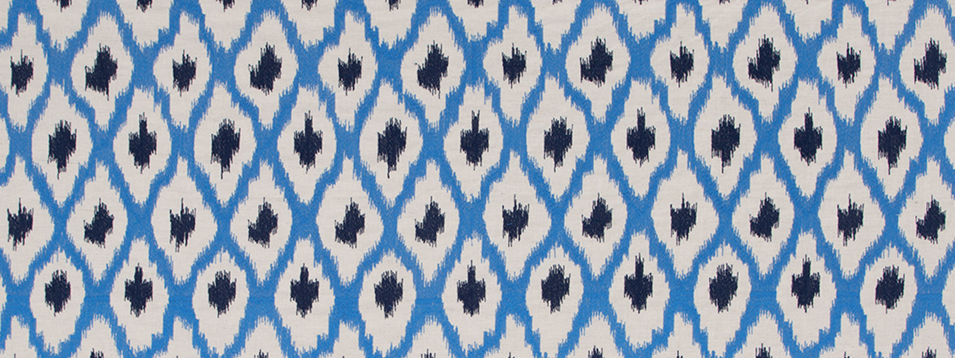 Blue and white ikat diamond-pattern textile with navy center accents.