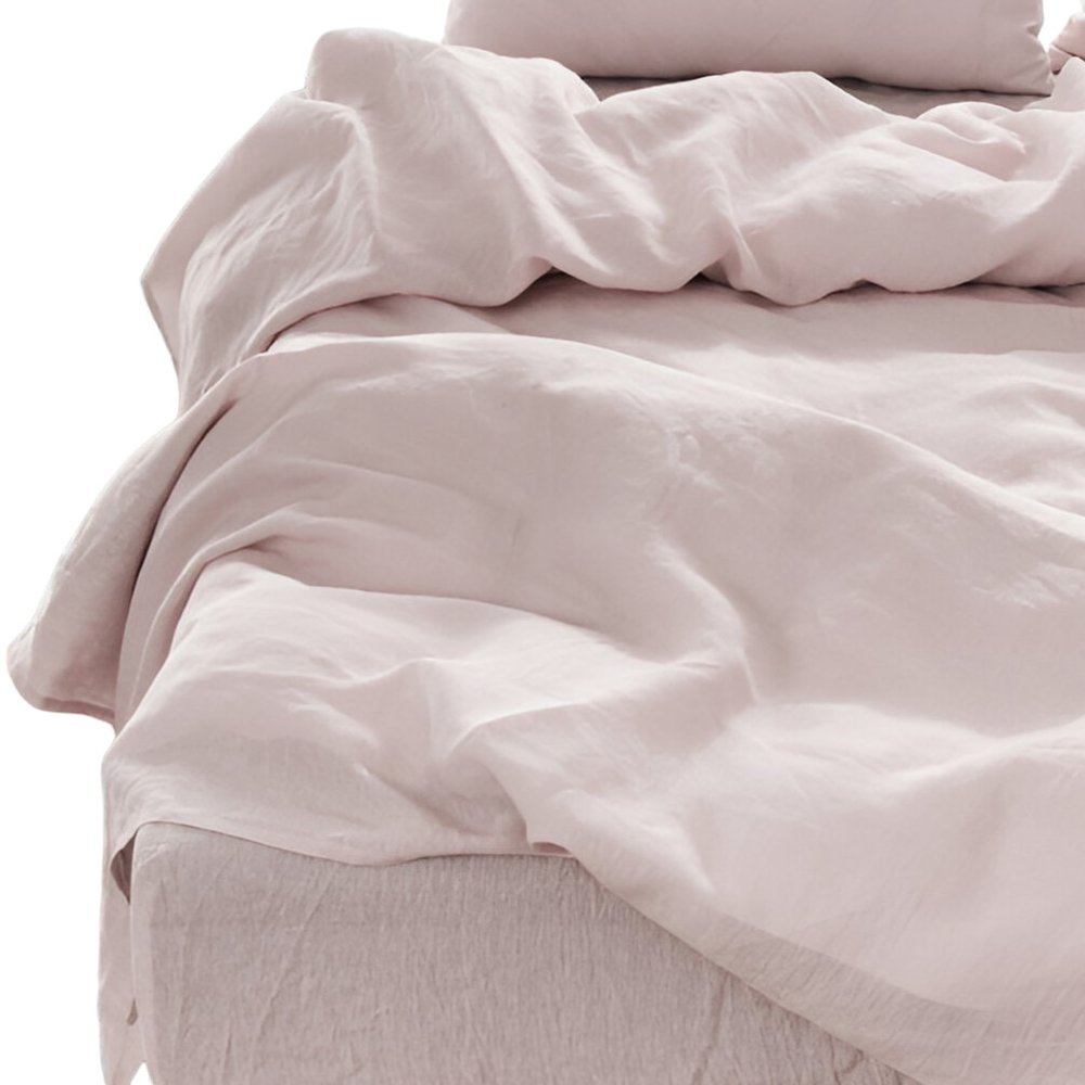 Light gray linen-look four-piece California King sheet set on a bed with wrinkled sheets and pillowcases.