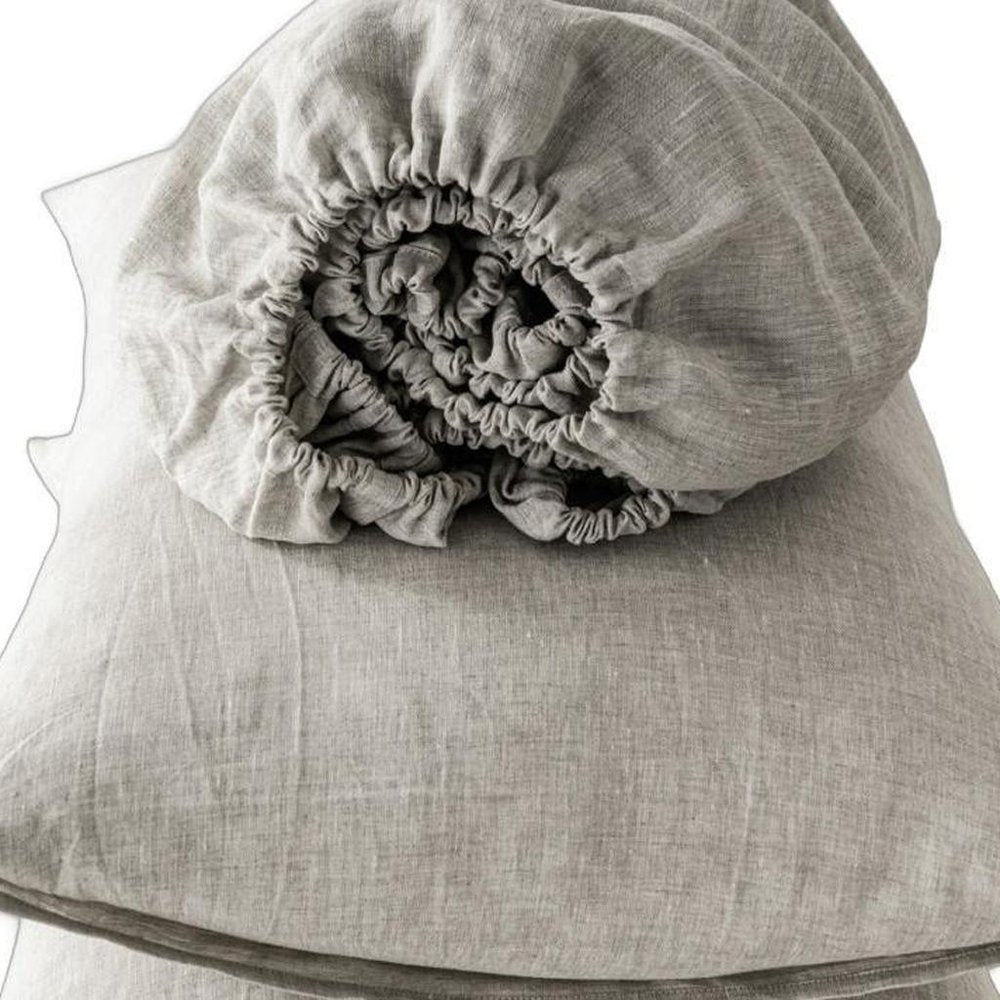 Light gray linen four-piece sheet set; wrinkled texture visible in a flat lay display.