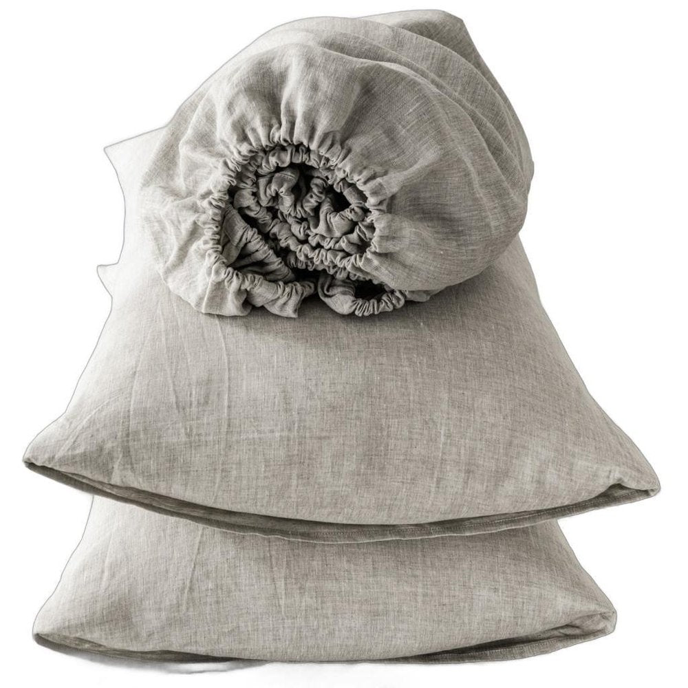 Four piece light gray linen sheet set, folded; soft, textured fabric for sheets and pillowcases.