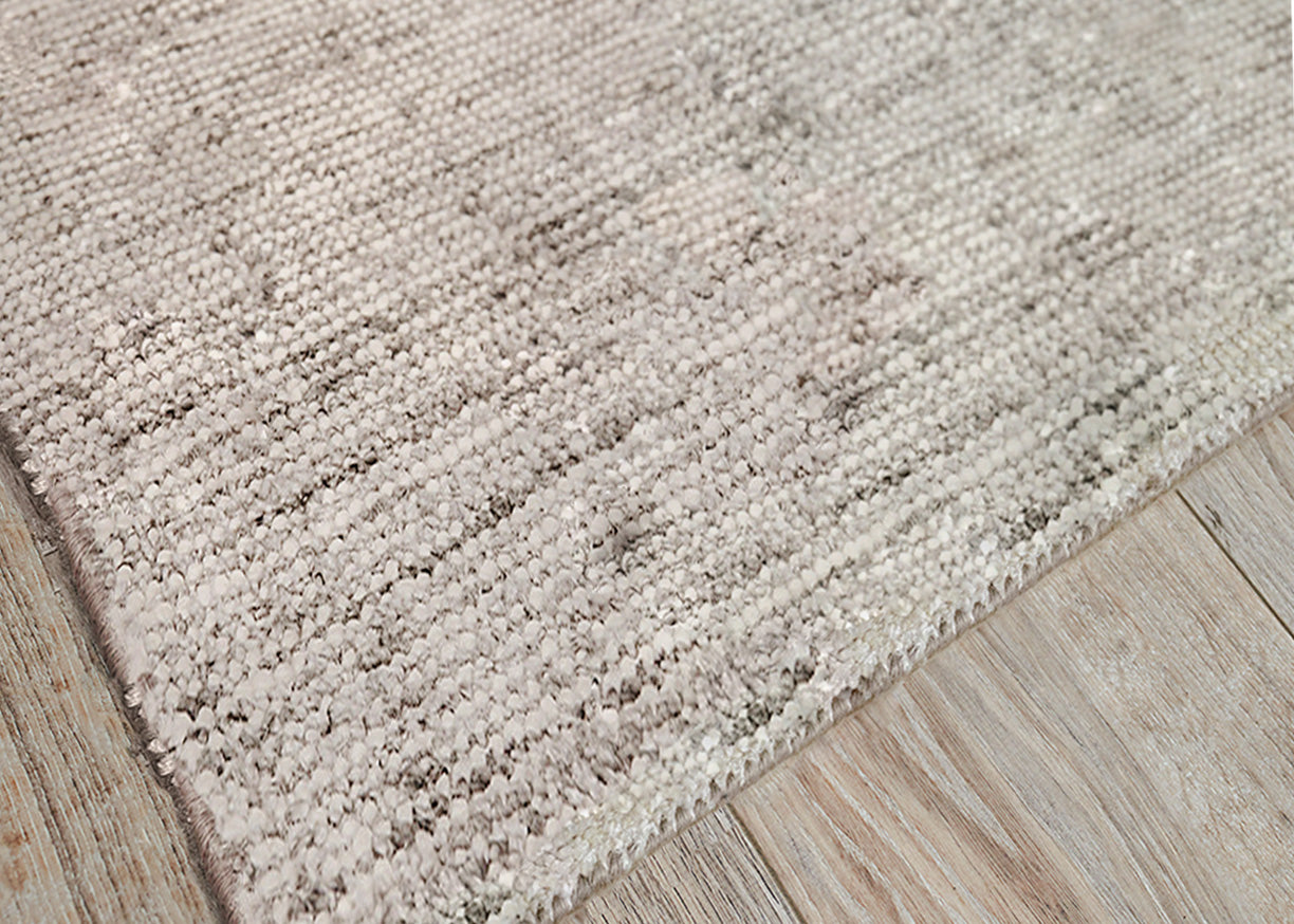Beige rug with dense pile on light wood floor.