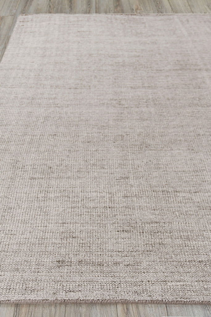 Beige textured area rug with a subtle tonal pattern, low-pile on wood floor