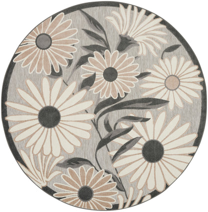 Round rug with beige and cream daisies on a gray background, dark centers and botanical leaves.