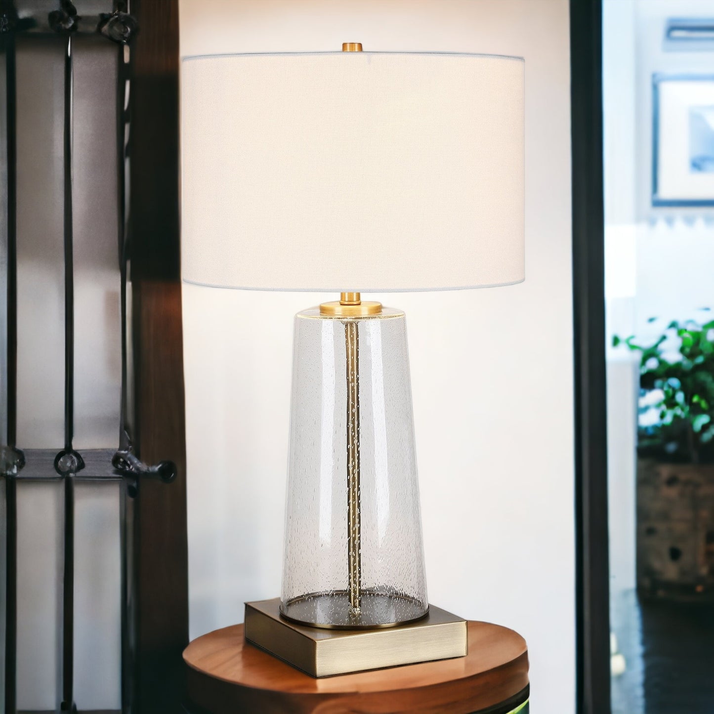 27" Brass and Clear Metal and Glass Table Lamp With White Drum Shade