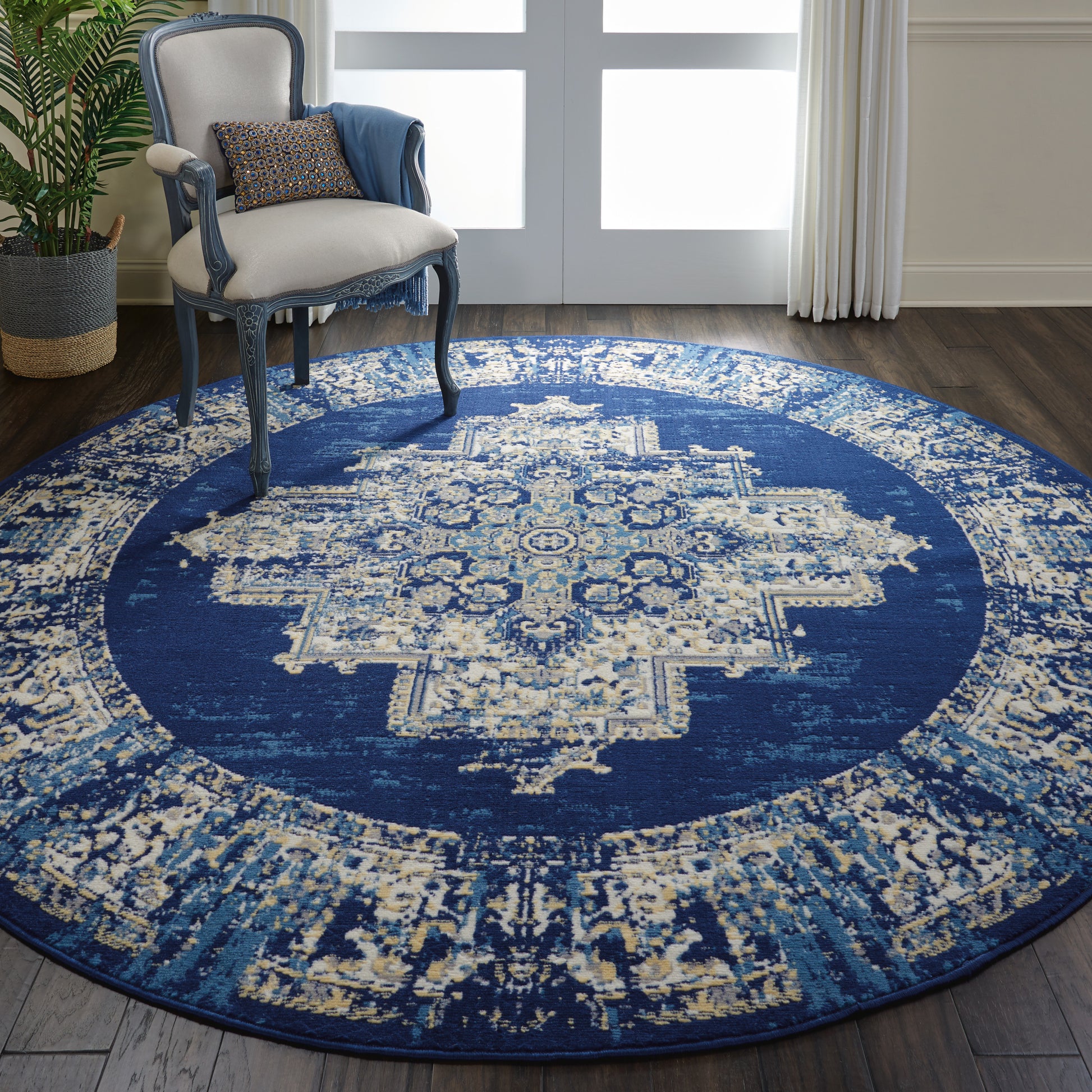 Round navy blue rug with ivory ornate medallion, vintage distressed pattern; ideal for living room seating.