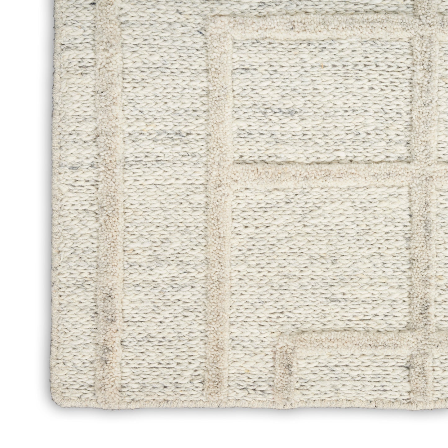 Cream woven bath rug with raised geometric rectangular pattern and soft looped pile.