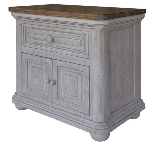 Distressed whitewashed wooden nightstand with dark wood top, single drawer and two-panel doors, rustic shabby chic style.