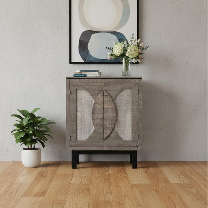 Gray textured wood cabinet with circular panel doors on black legs, topped with abstract art and a vase of flowers.