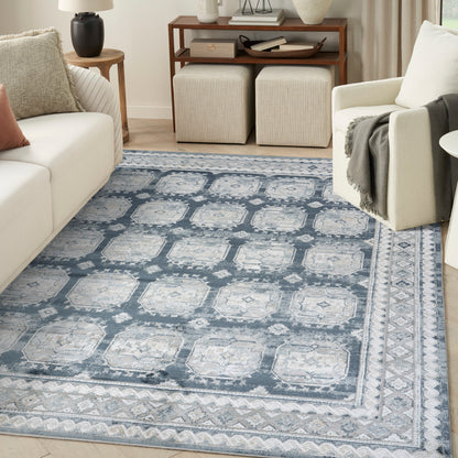 Blue-gray oriental style area rug with ivory medallions and geometric borders in a modern neutral living room.