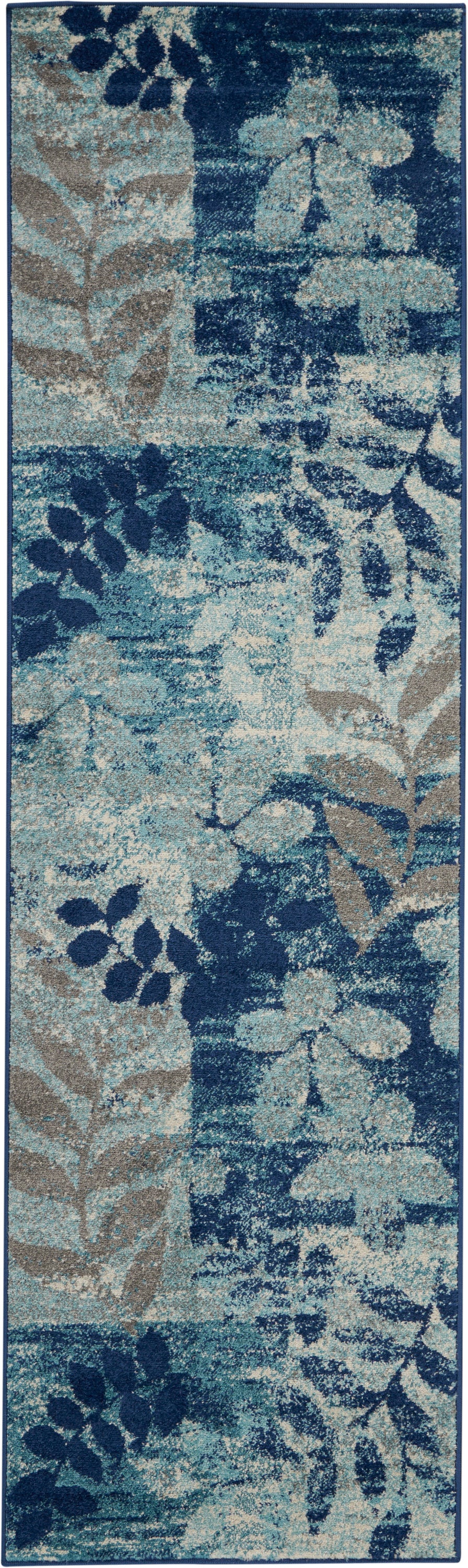 Long navy blue botanical runner rug with teal and beige leaf motifs; plush textured pile and dark border.