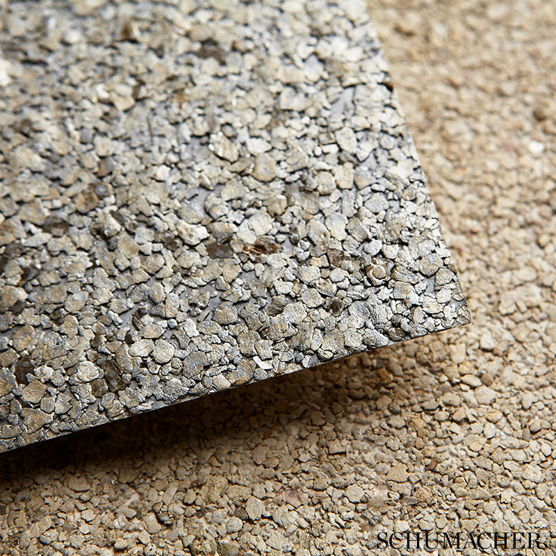 Gray crushed-pebble stone tile with rough textured surface and squared edge on beige substrate.