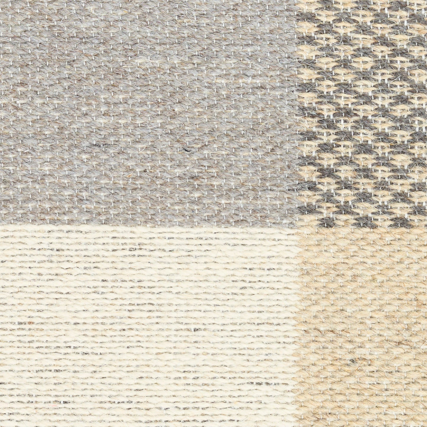 Patchwork rug with four textures: grey tweed, beige weave, cream knit stripes, and tan jute-like weave.