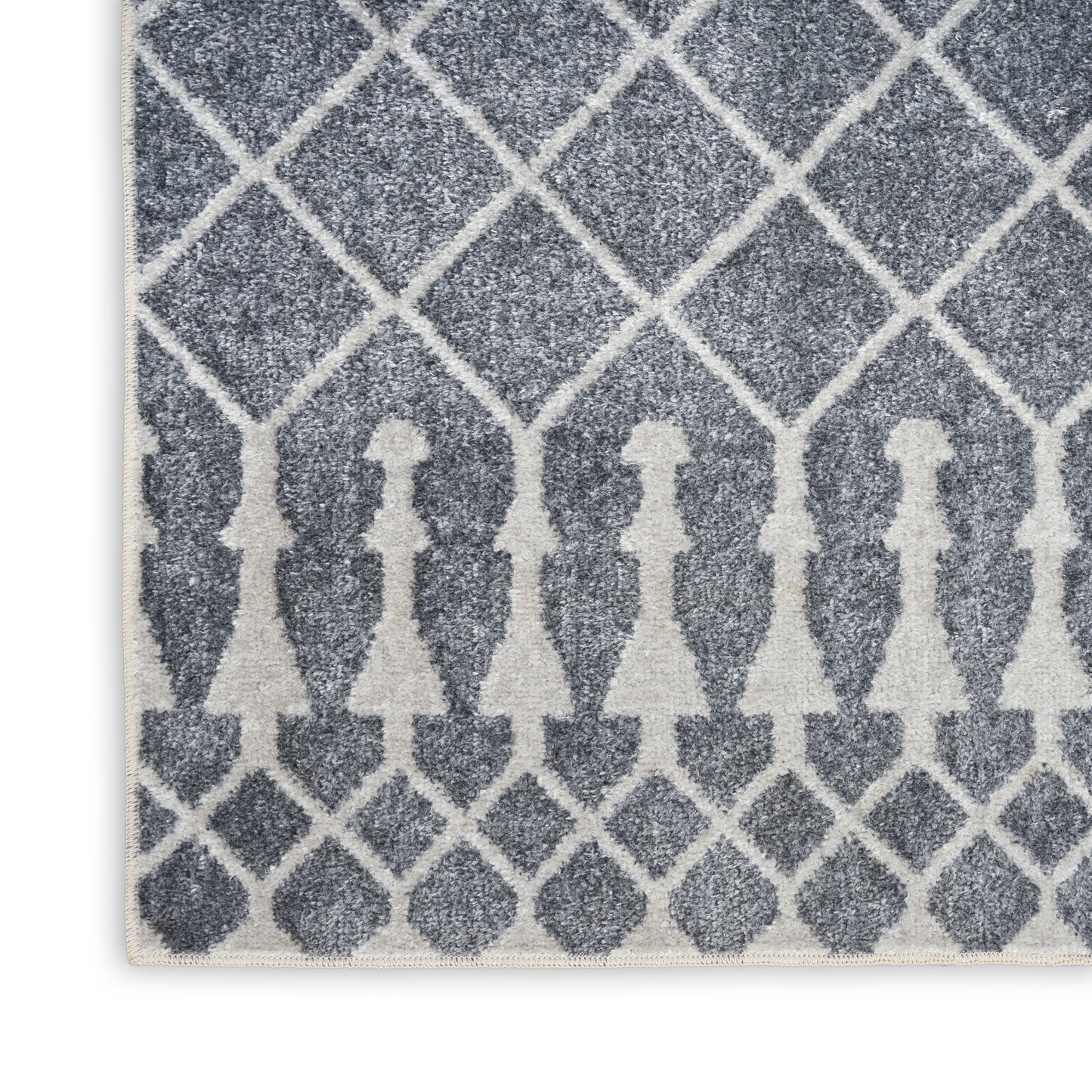 Blue-gray textured rug with white diamond lattice pattern and row of white silhouette figures along the bottom edge.