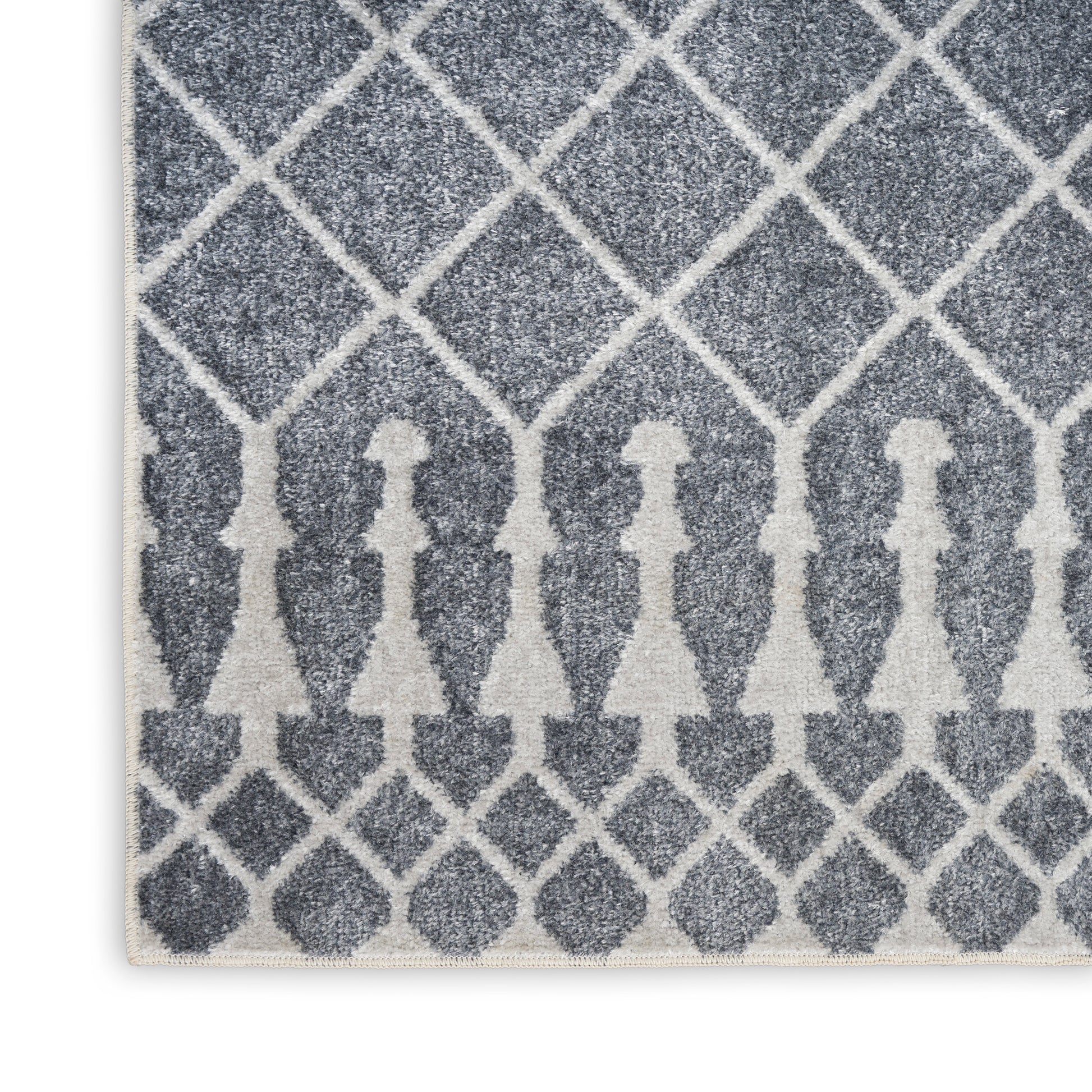 Blue-gray textured rug with white diamond lattice pattern and row of white silhouette figures along the bottom edge.