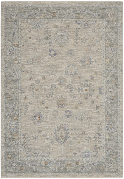 Rectangular beige rug with pale blue floral motifs and decorative border; vintage distressed oriental style.