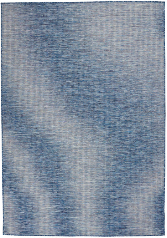 Blue denim-toned woven rug, rectangular with subtle textured grid pattern; casual, contemporary living room accent.