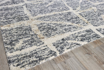 Charcoal gray and ivory hand-knotted rug with a large geometric grid pattern on wood floor