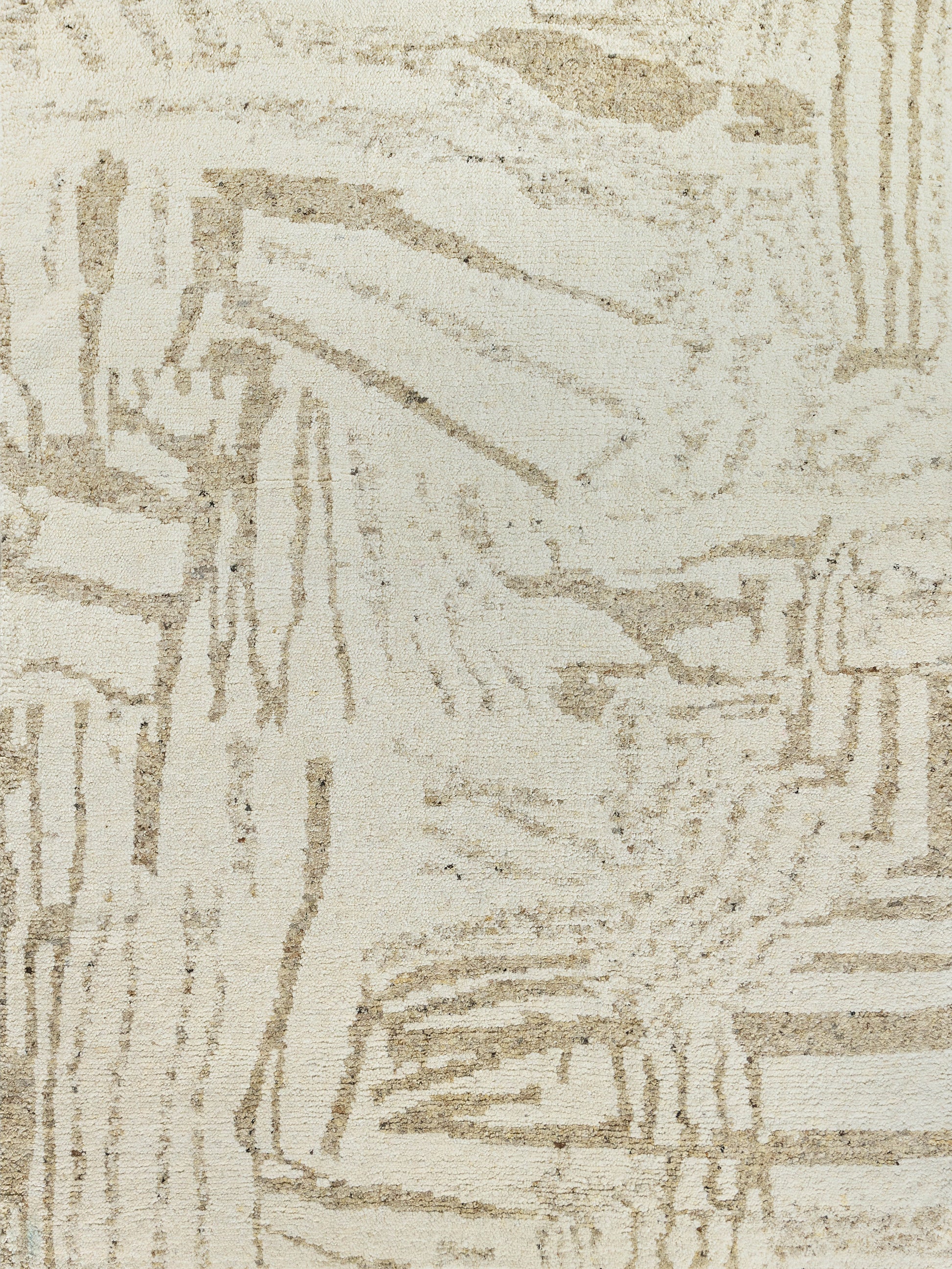 Beige and cream textured rug with abstract geometric pattern; woven neutral decor for living spaces.