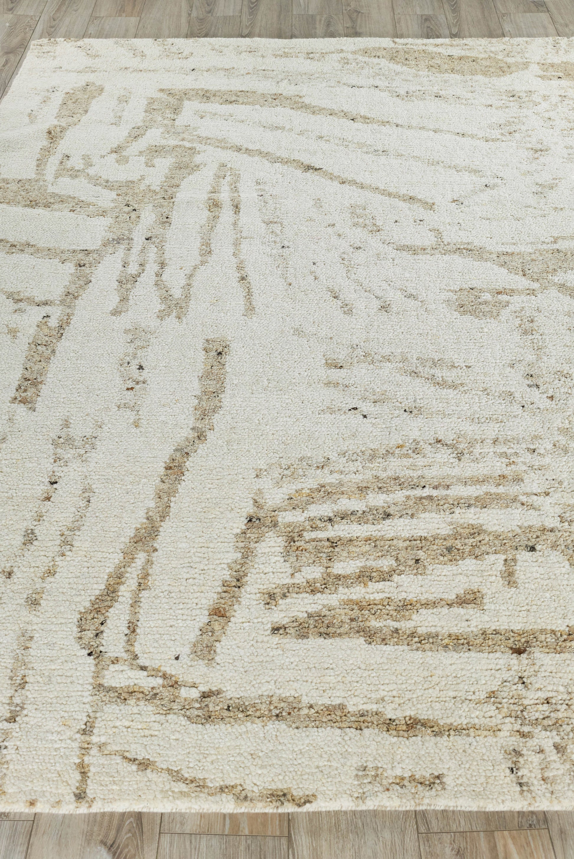 Rectangular beige indoor hand-knotted rug with abstract taupe lines, modern geometric pattern and soft textured pile.