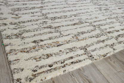 Beige cream area rug with brown irregular stripes on light wood floor.