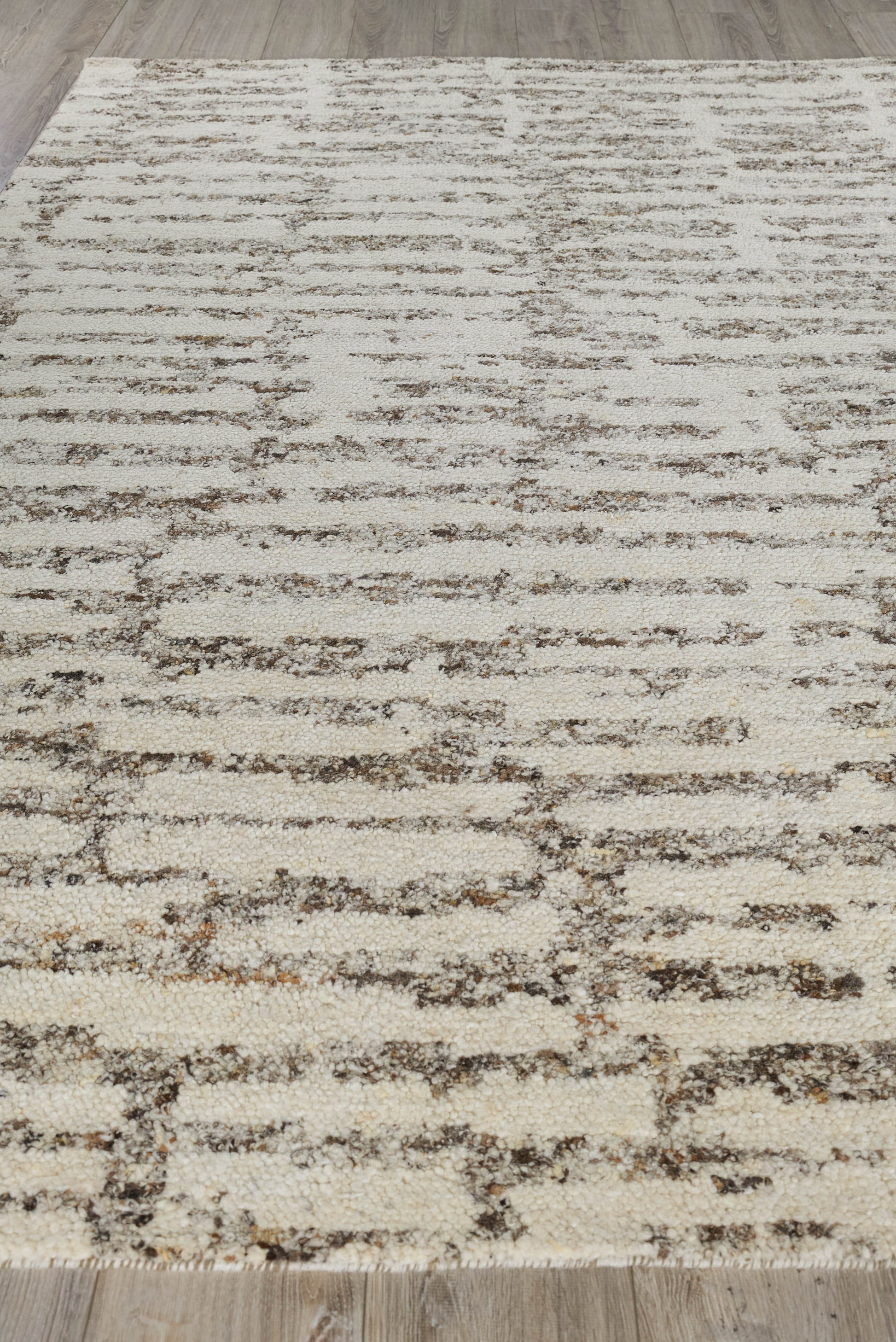 Beige cream area rug with abstract brown horizontal lines and a distressed pattern; modern living room decor.