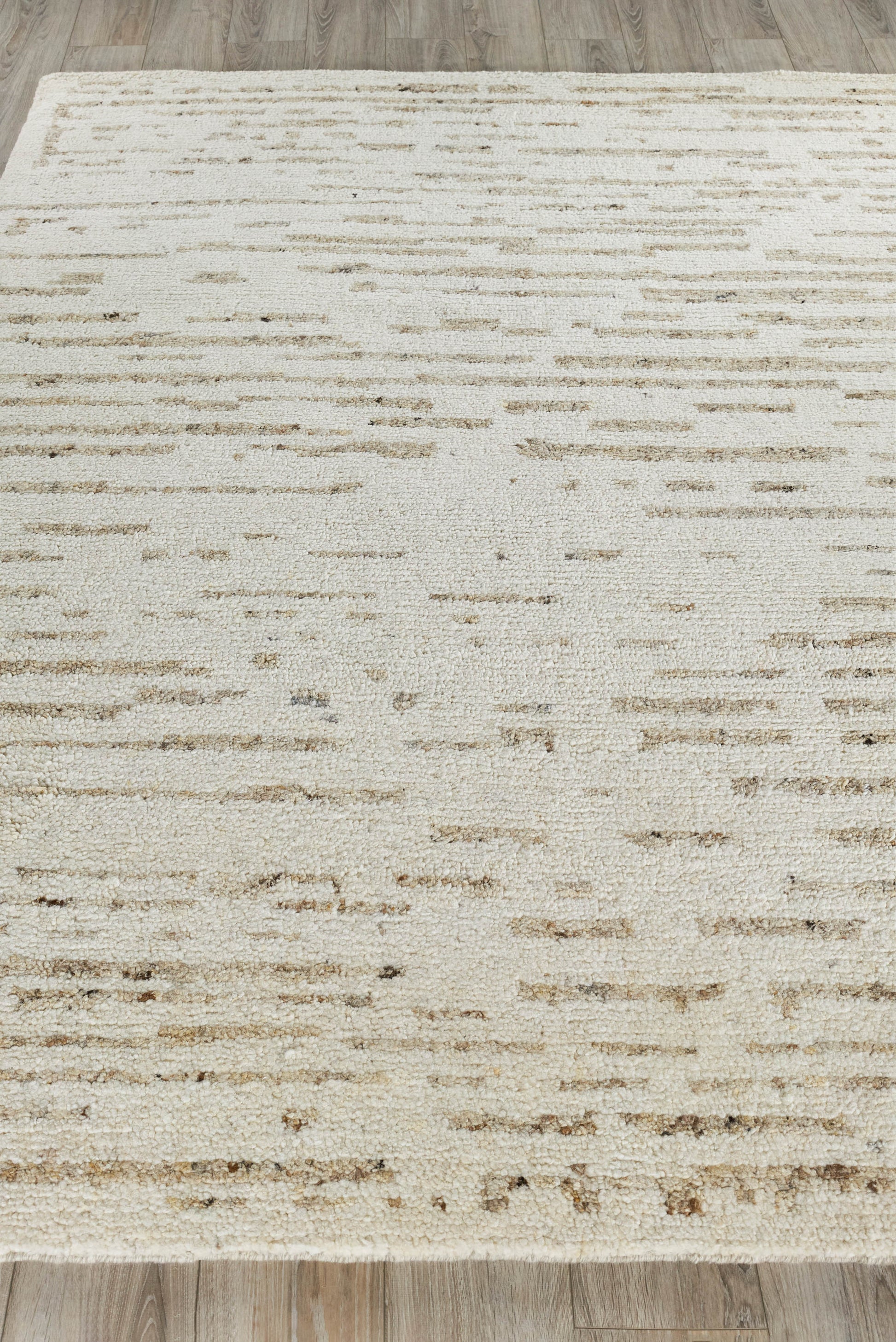 Neutral cream rug with subtle beige linear streaks, low-pile, modern abstract design for living rooms.