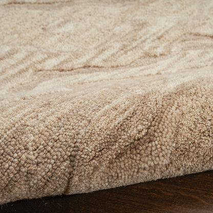 Beige plush area rug with dense loop pile, soft texture shown on dark wood floor.