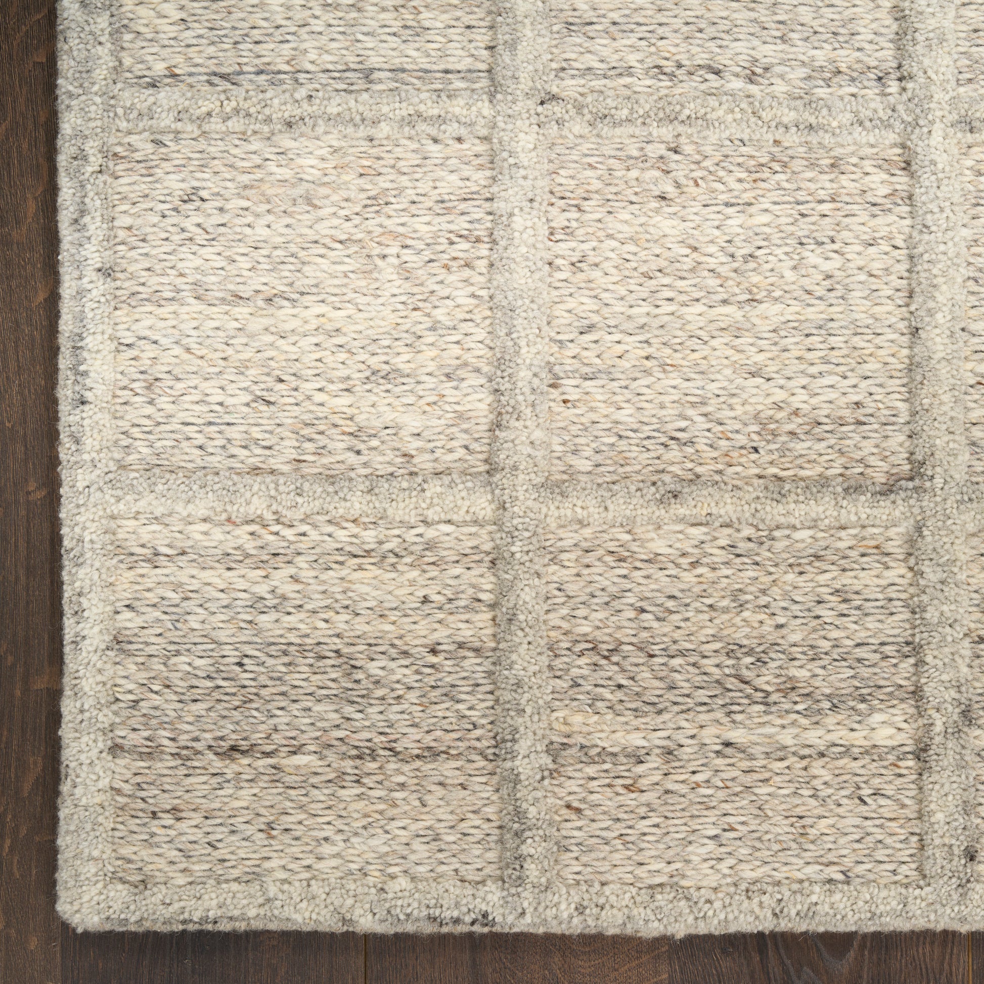 Beige textured woven rug with a grid of rectangular panels and chunky loops; natural fiber look.