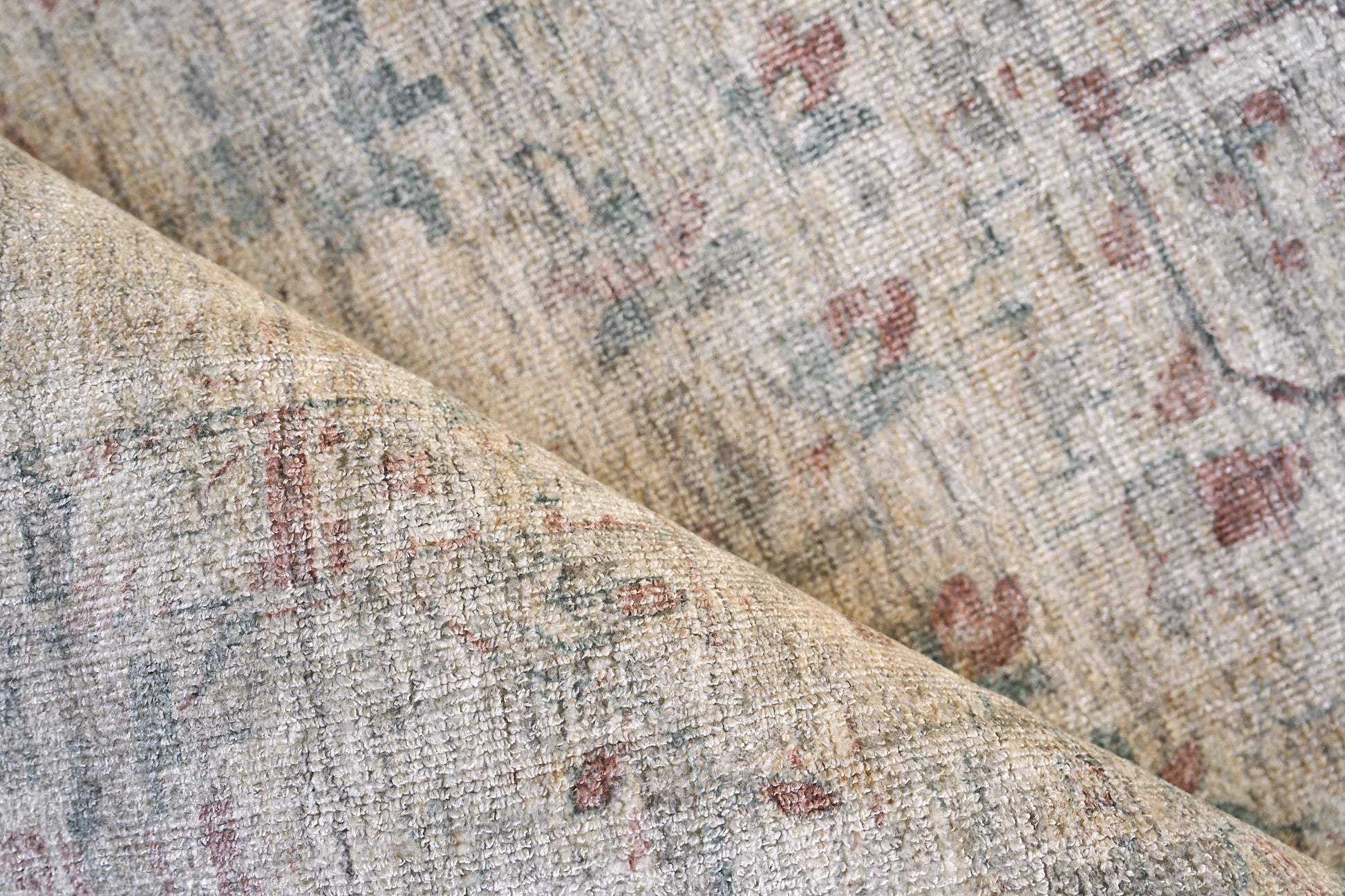 Beige distressed Persian-inspired rug with faded blue, pink and green floral motifs; soft woven texture.