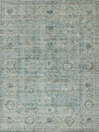 Distressed teal-blue area rug with faded floral medallions and beige accents; rectangular, vintage oriental-inspired decor.