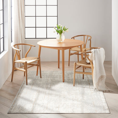 Round light-wood dining table with matching chairs, vase of white tulips, cream throw blanket, bright Scandinavian dining nook.