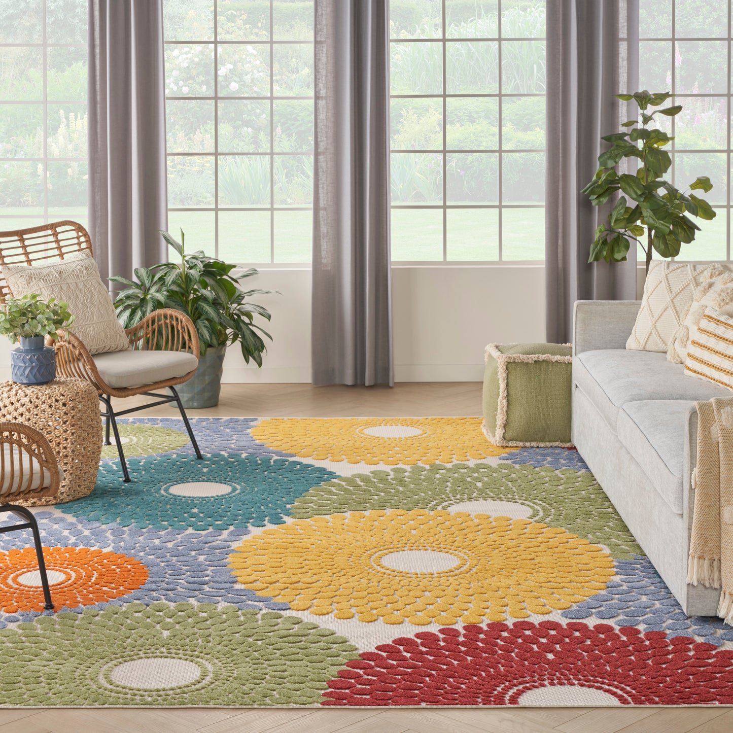 Colorful rectangular rosette area rug with petal-like circles in yellow, orange, red, green, blue in a bright living room.