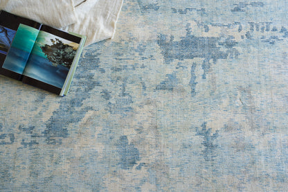 Blue & cream distressed abstract area rug; woven texture, rectangular, ideal for living room decor.