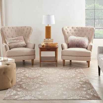 Two beige tufted armchairs with nailhead trim flank a wooden end table and lamp in a cozy beige living room with a rug.