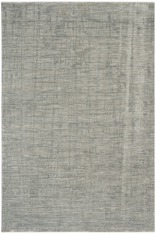 Grey distressed area rug with subtle abstract grid pattern in soft blue-gray tones, modern minimalist style.