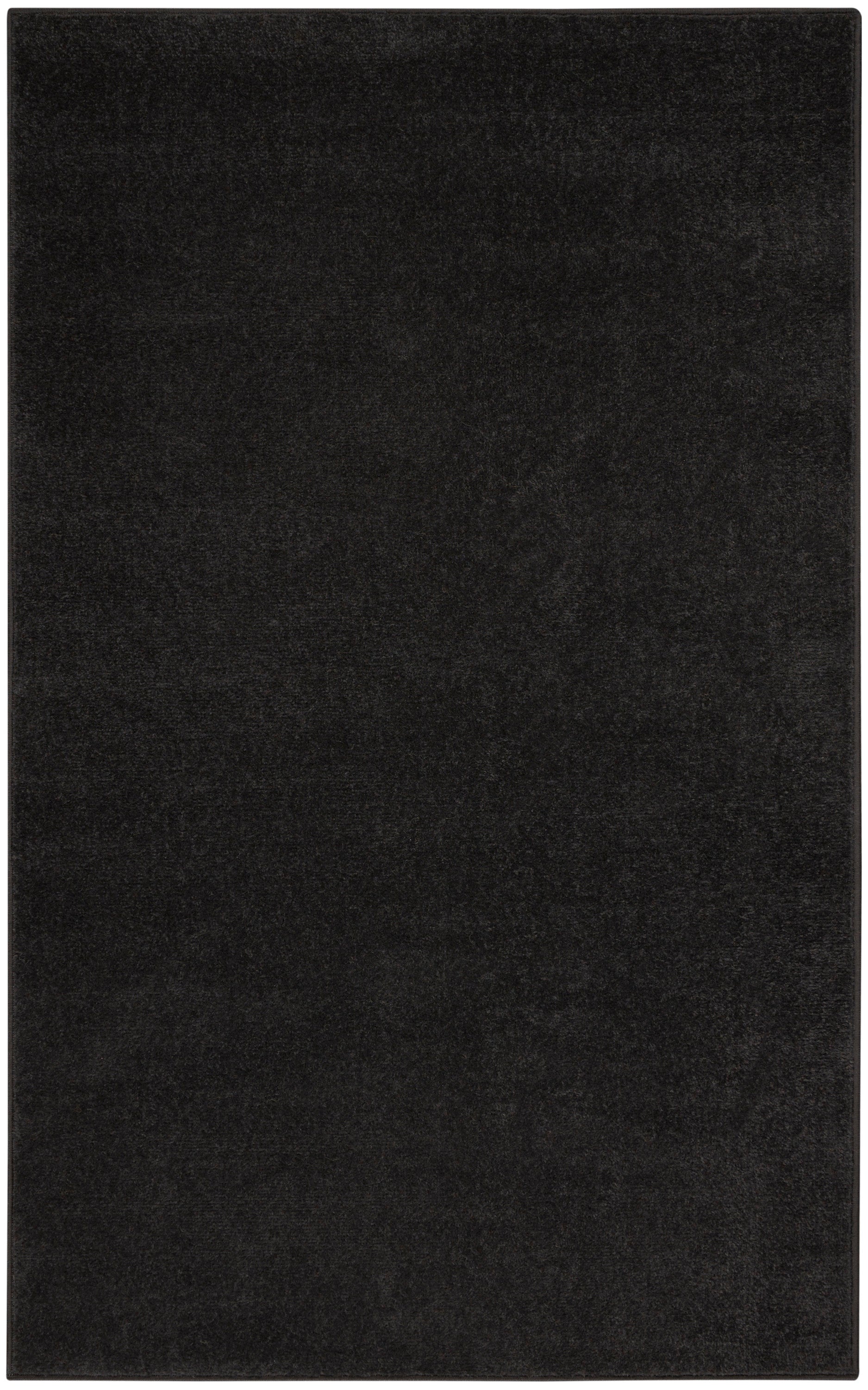 Black rectangular rug with dense plush pile; minimalist floor covering.