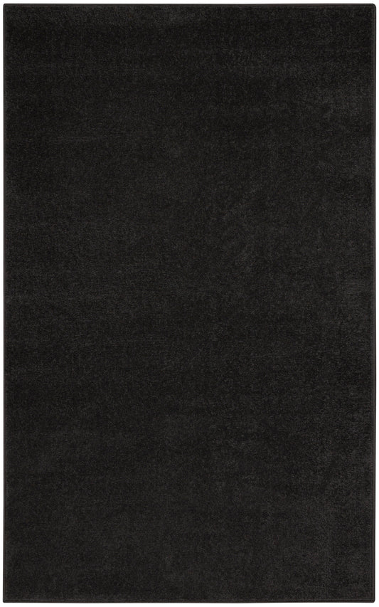 Black rectangular rug with dense plush pile; minimalist floor covering.