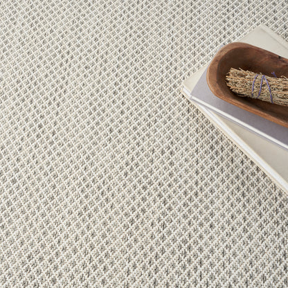 Beige rectangular swatch with smooth matte finish on textured gray fabric background.