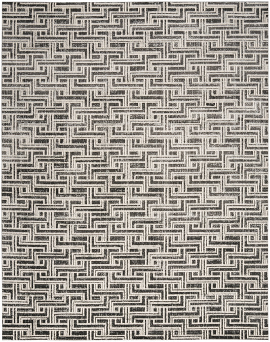 Black and white woven rug with a repeating Greek key maze pattern; bold geometric texture.