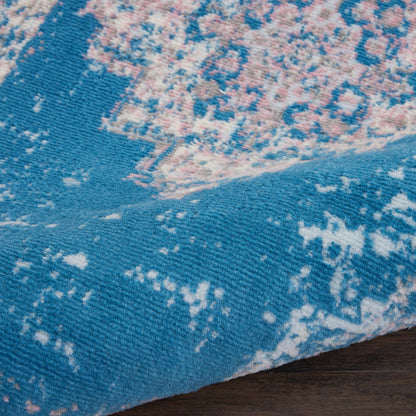 Teal blue runner rug with pink and cream distressed pattern; soft woven pile.