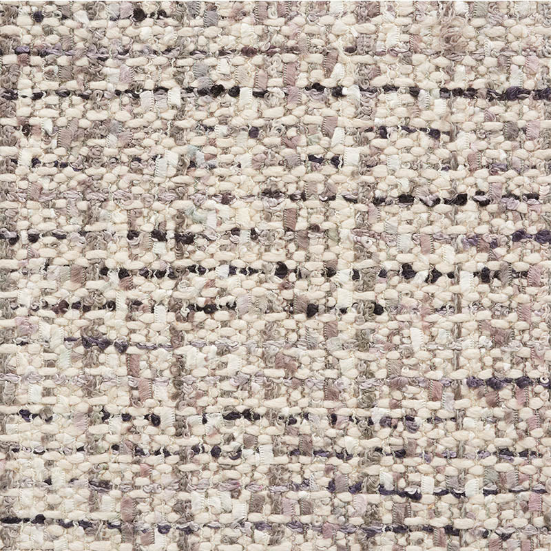 Close-up of a textured boucle rug in cream, beige and lilac with chunky, looped fibers.