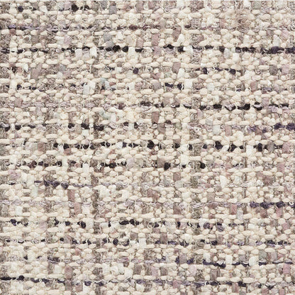 Close-up of a textured boucle rug in cream, beige and lilac with chunky, looped fibers.