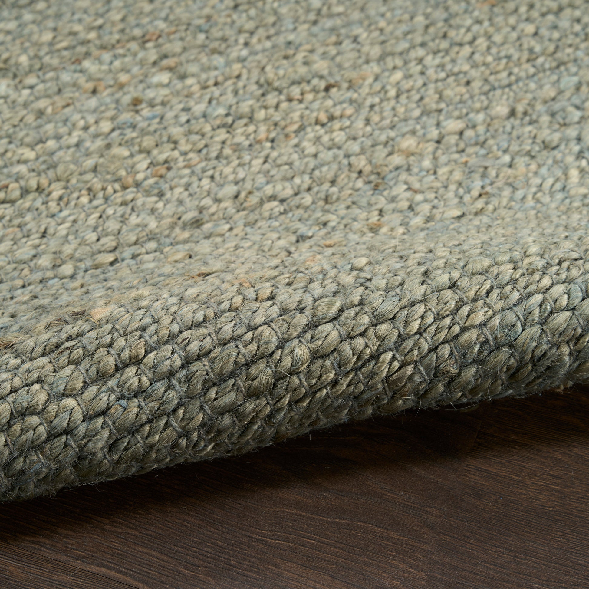 Grey-blue speckled loop-pile rug with braided edge; sturdy woven texture for living rooms.